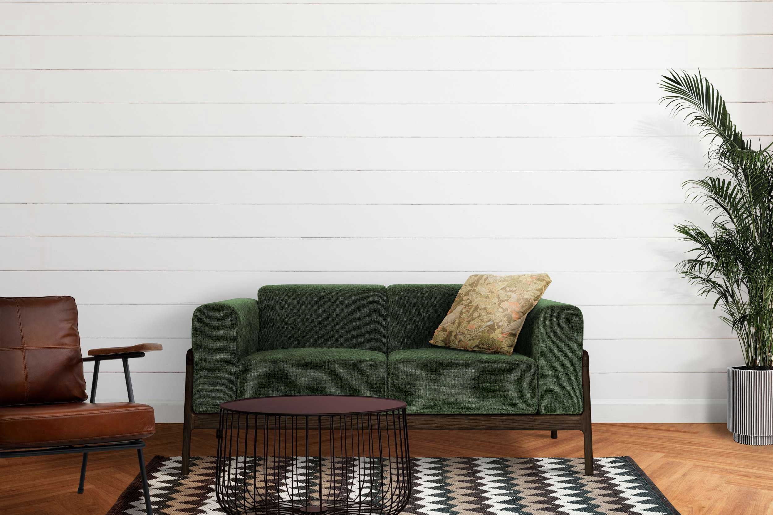 A green couch and chair positioned in front of a clean white wall, creating a fresh and inviting living space