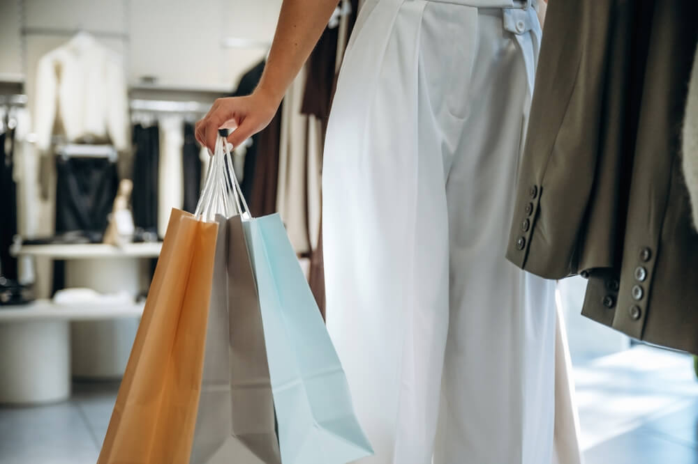Discover Denver’s Cherry Creek Shopping District 1 A person holding multiple shopping bags inside a clothing store.